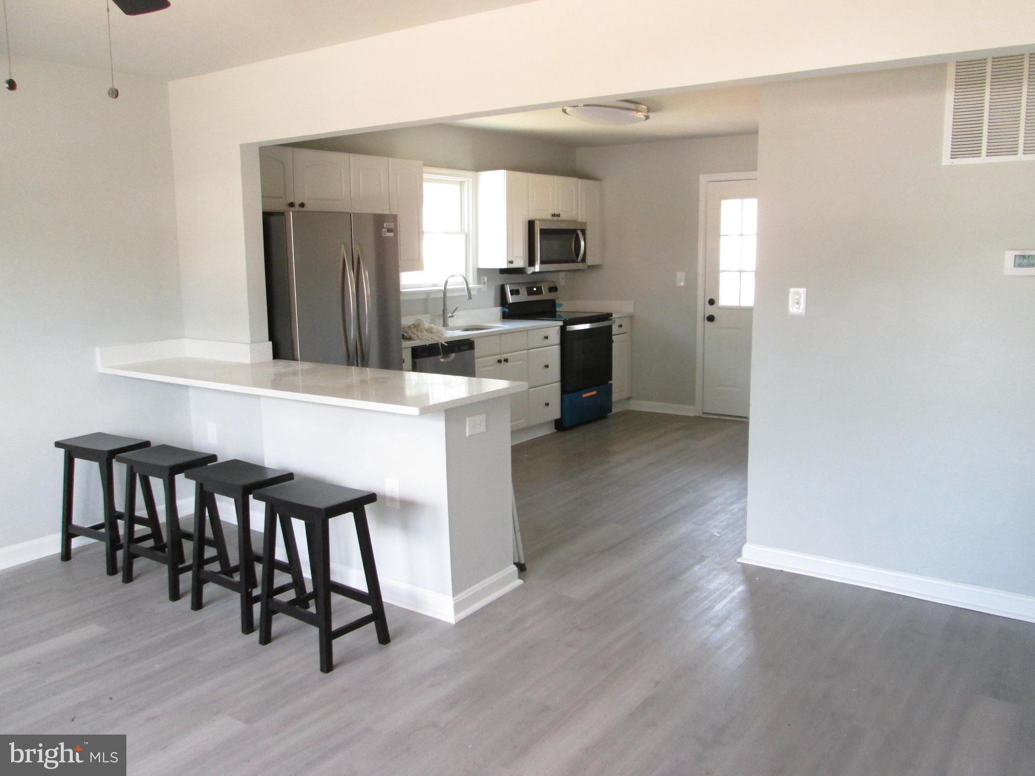 a kitchen with kitchen island granite countertop wooden floors and stainless steel appliances