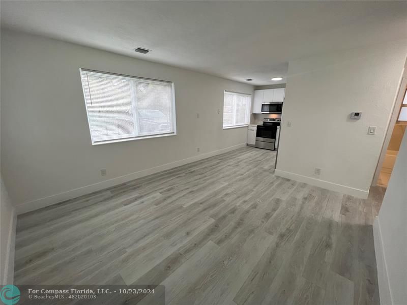 a view of empty room with wooden floor