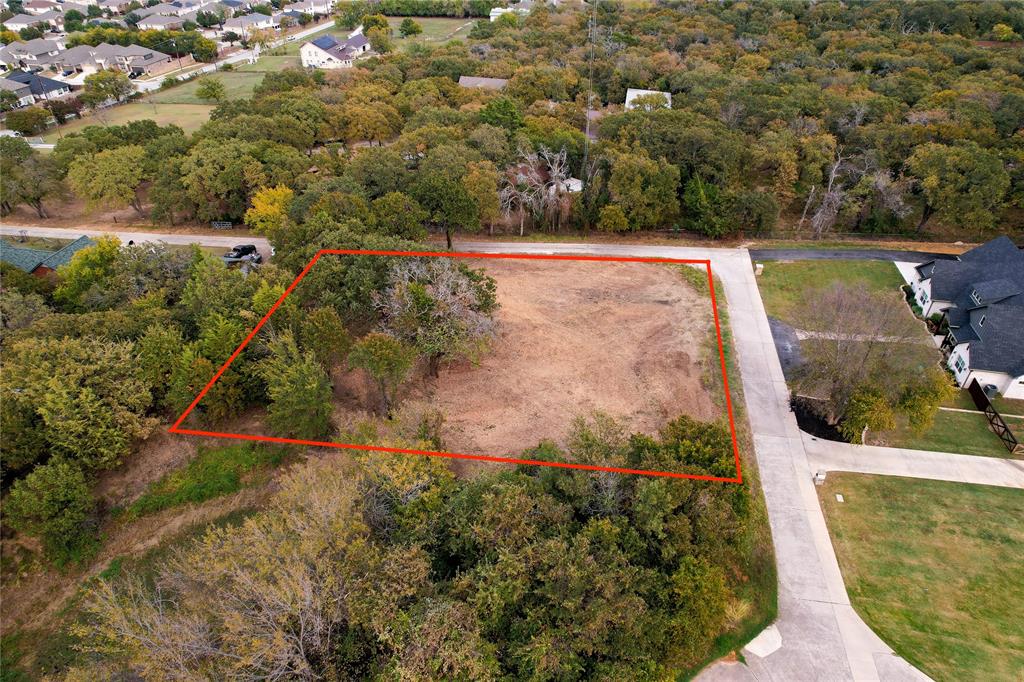 an aerial view of a house with a yard and lake view