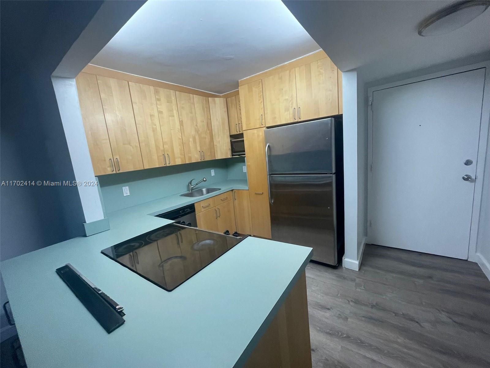 a kitchen with a refrigerator sink and cabinets