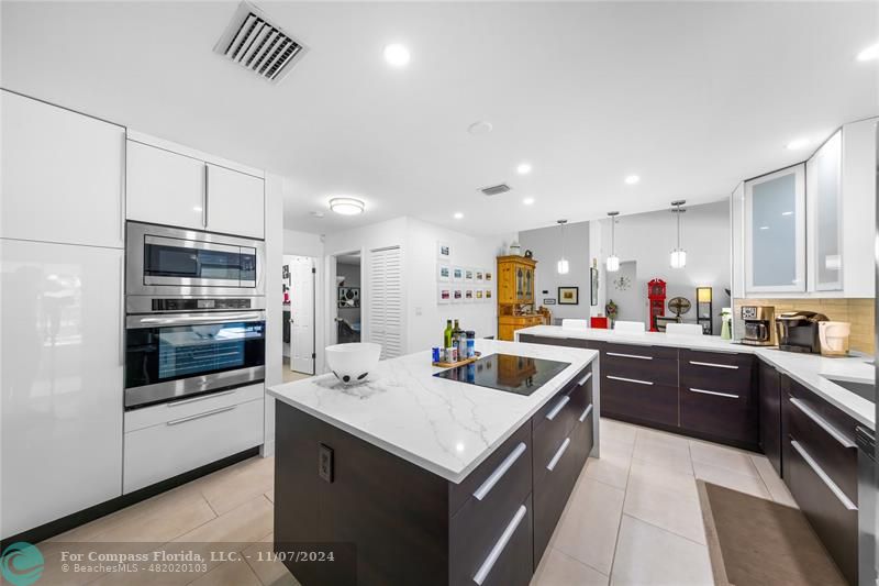 a kitchen with stainless steel appliances granite countertop a sink and a refrigerator