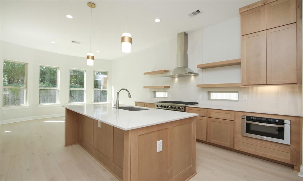 a kitchen with stainless steel appliances granite countertop a sink a stove and a refrigerator