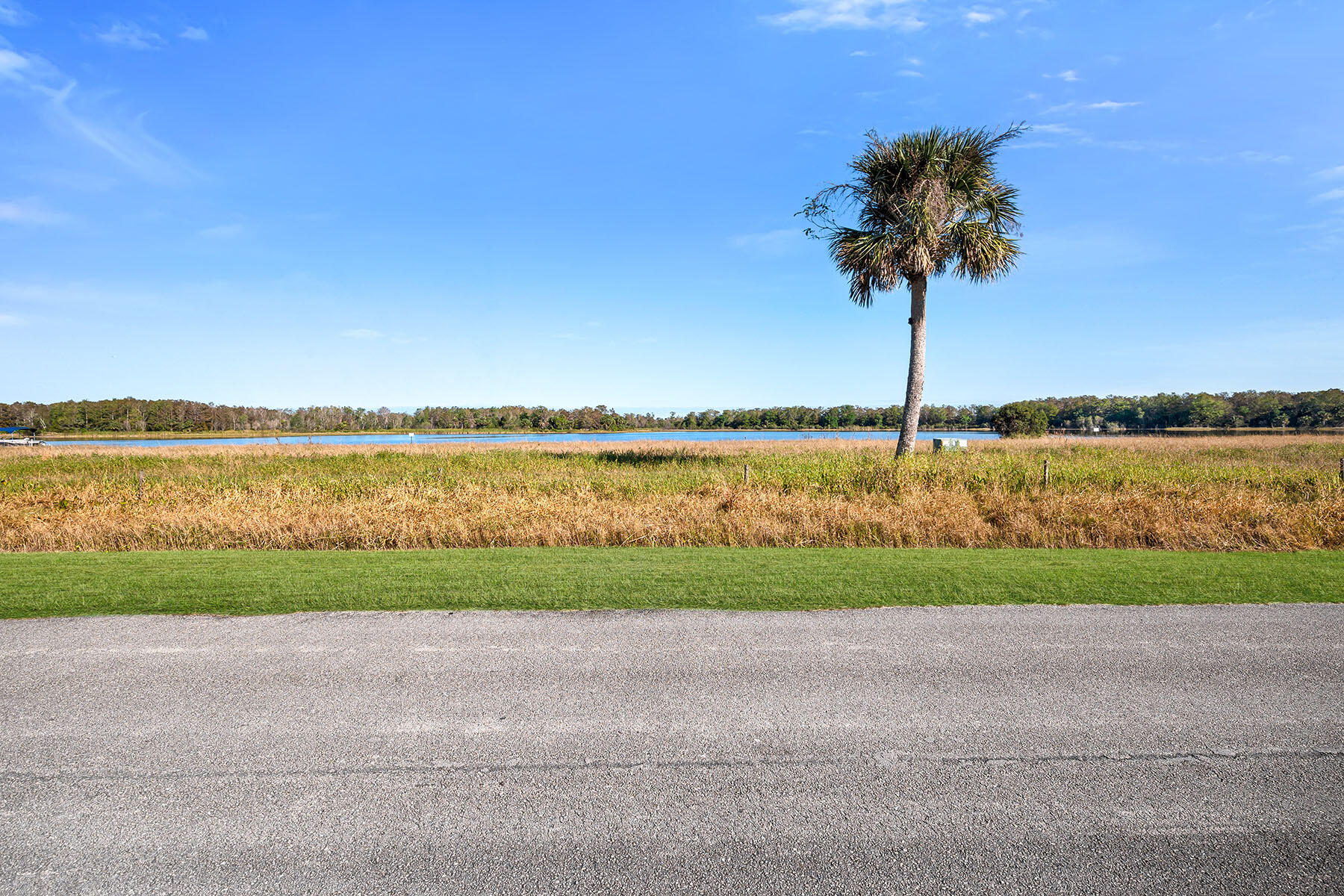 a front view of a house with a yard and lake view