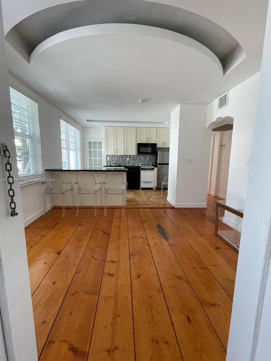 a large kitchen with cabinets and wooden floor