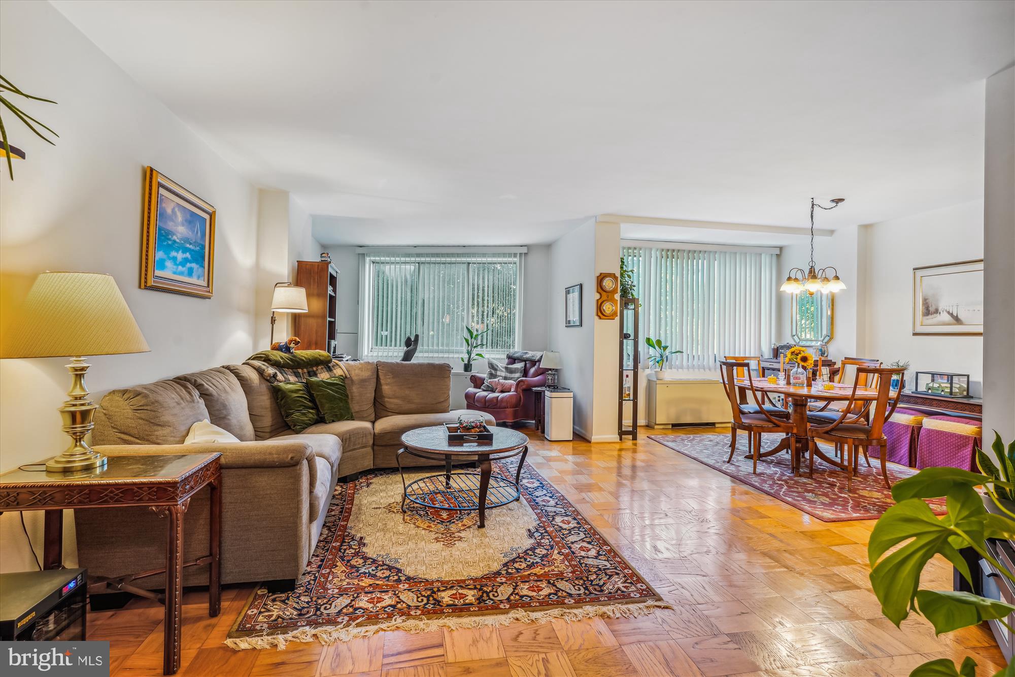 a living room with furniture and a dining table with wooden floor