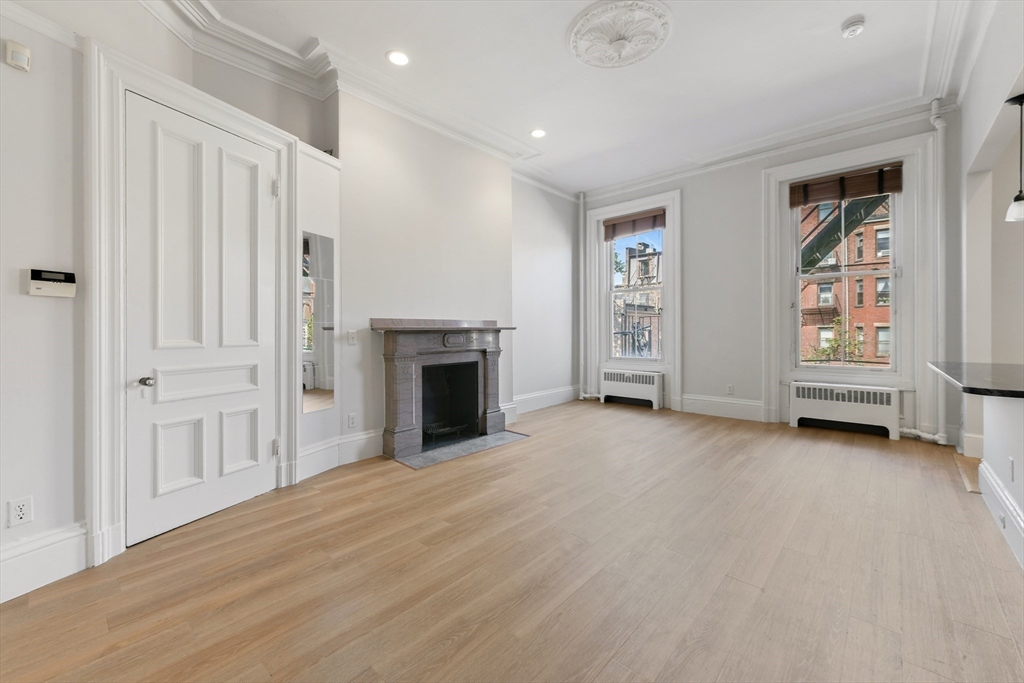 an empty room with windows and fireplace