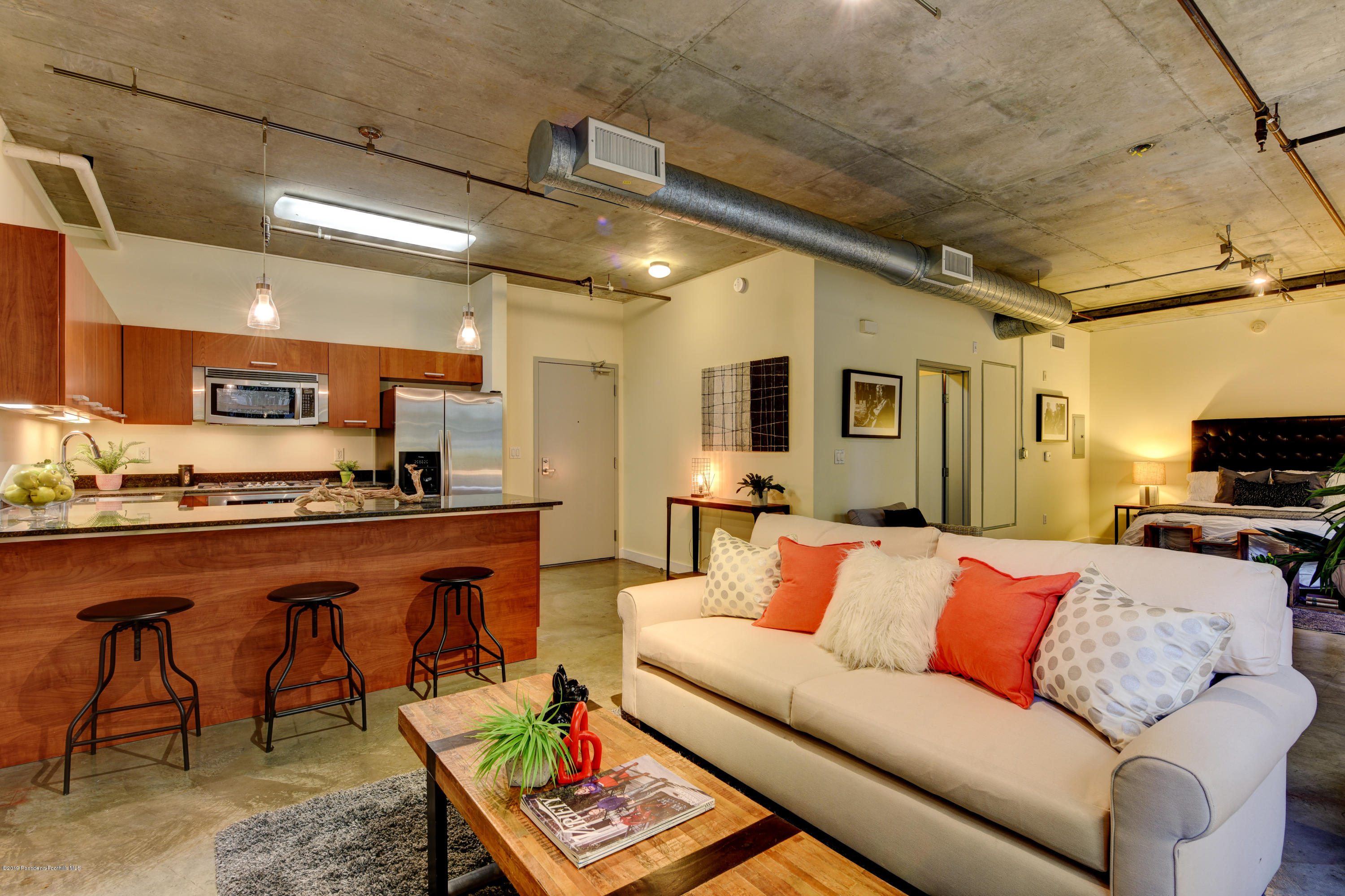 a living room with furniture a flat screen tv and kitchen view