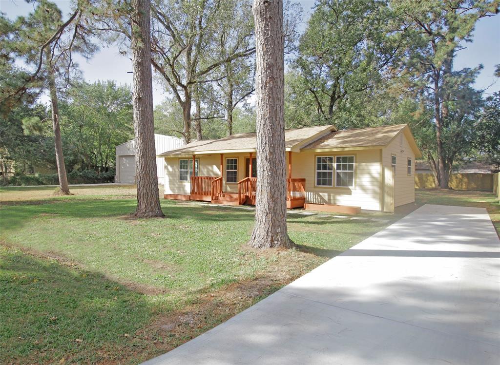 a view of a house with backyard and a tree