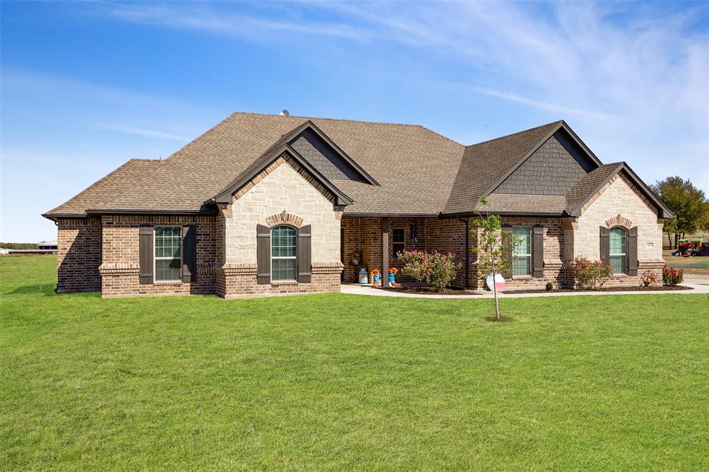 a view of a house with a yard and sitting area