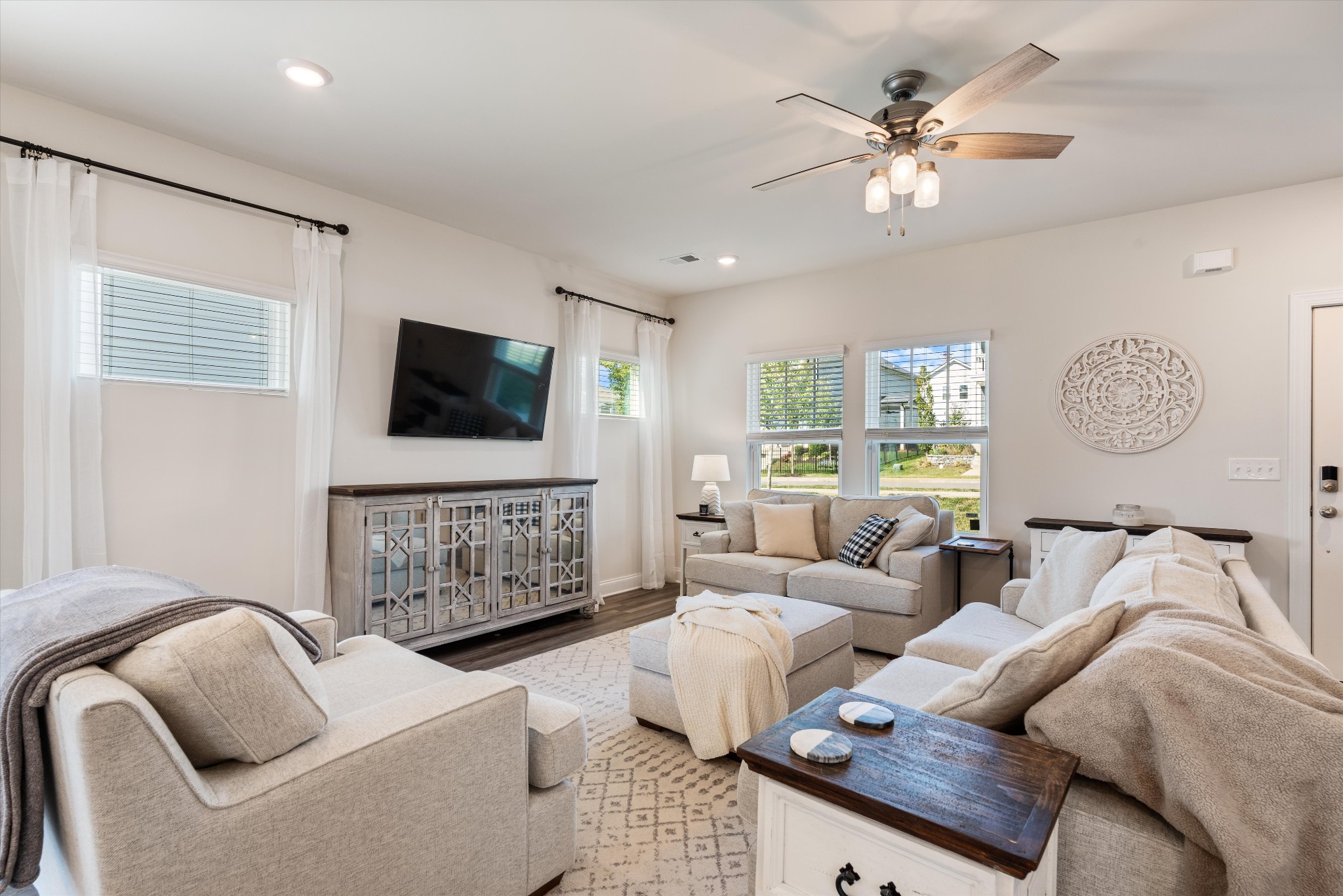 a living room with furniture a flat screen tv and a window