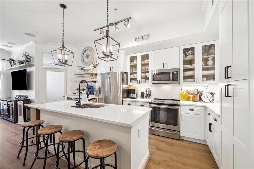 a kitchen with stainless steel appliances kitchen island granite countertop a sink and cabinets