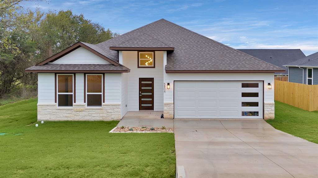 a front view of a house with a yard and garage