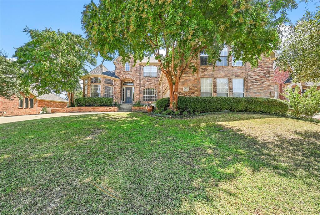 a view of a house with a big yard and large trees