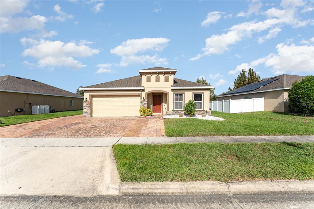 a front view of a house with a yard and garage