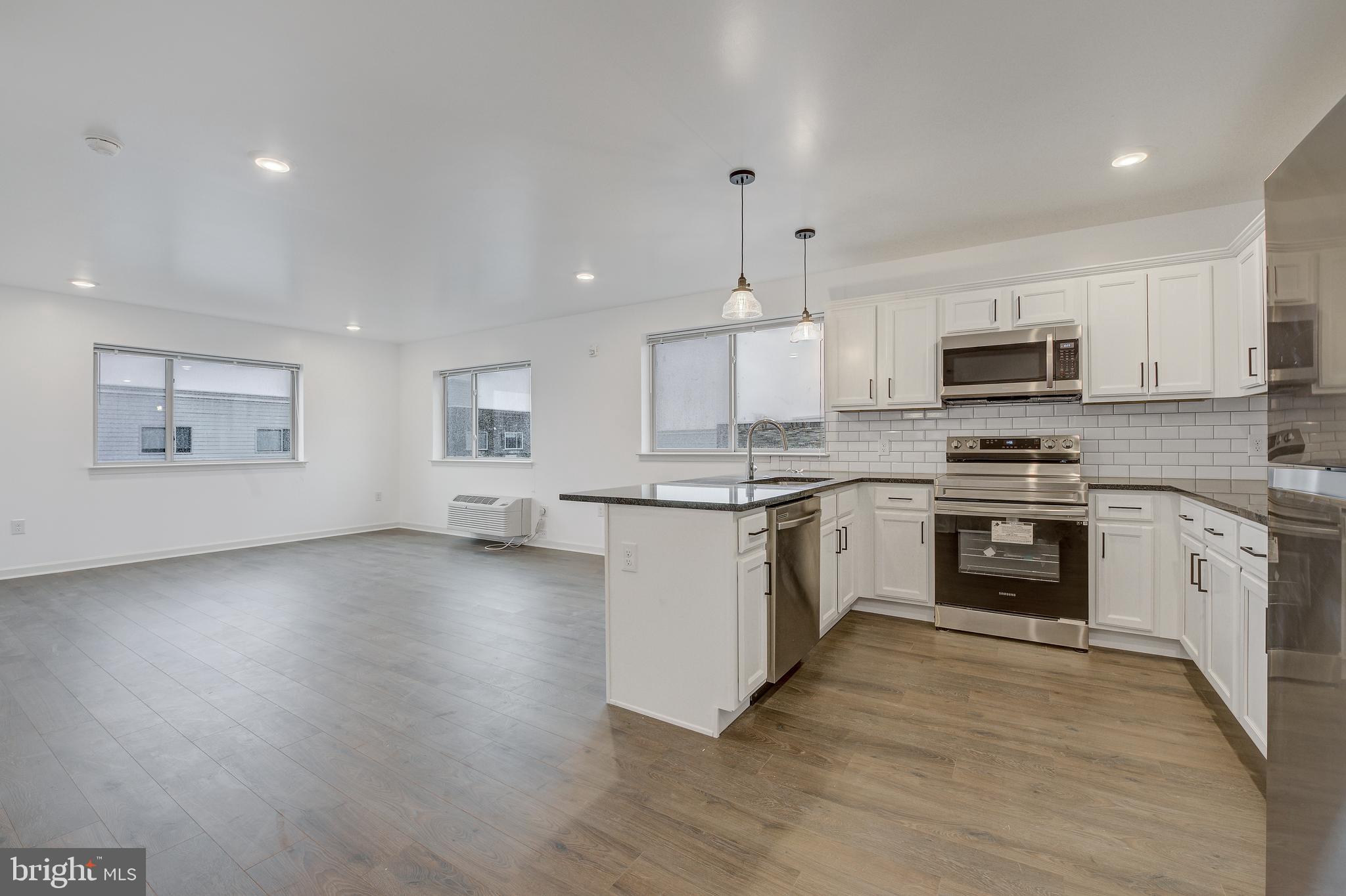 a kitchen with granite countertop a stove top oven and cabinets