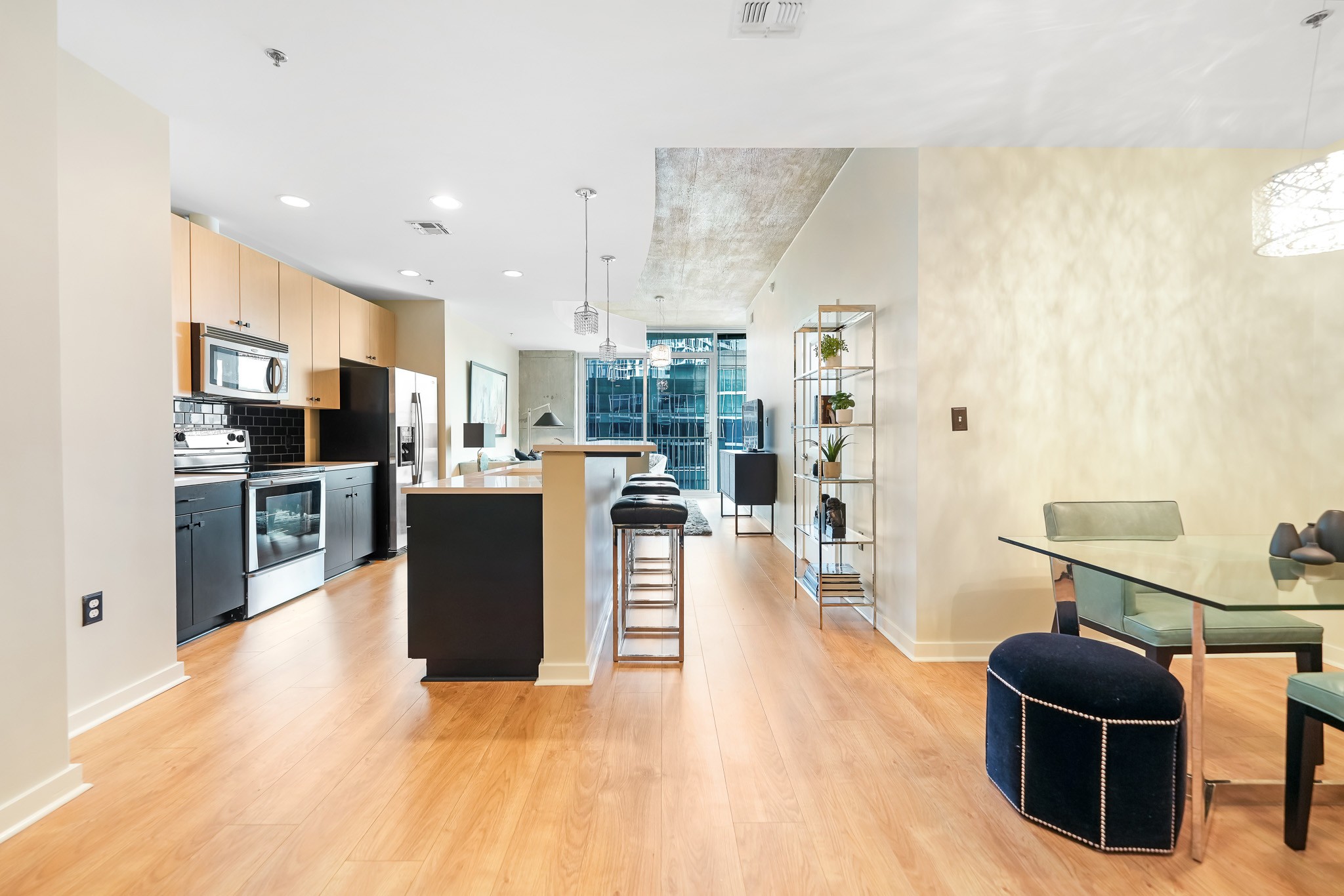 a view of kitchen with stainless steel appliances kitchen island granite countertop a refrigerator and cabinets