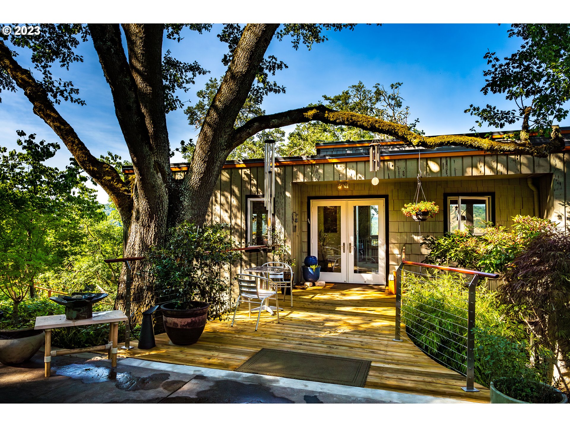 a view of a house with large windows and a flower garden