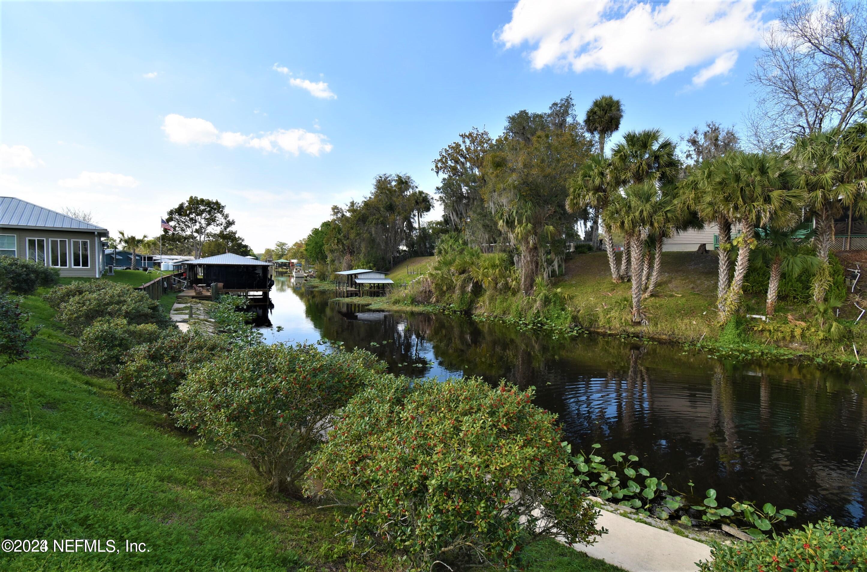 a backyard of a house with lots of green space and lake view