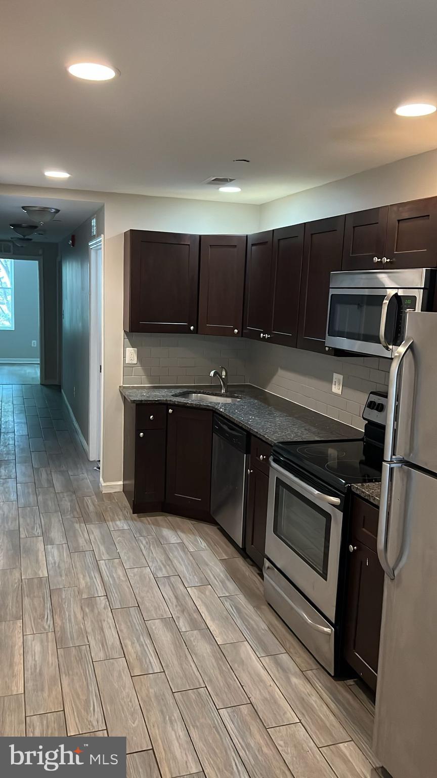 a kitchen with kitchen island granite countertop a stove and a sink