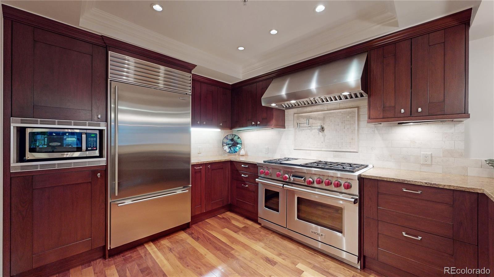 a kitchen with stainless steel appliances wooden cabinets and a stove top oven