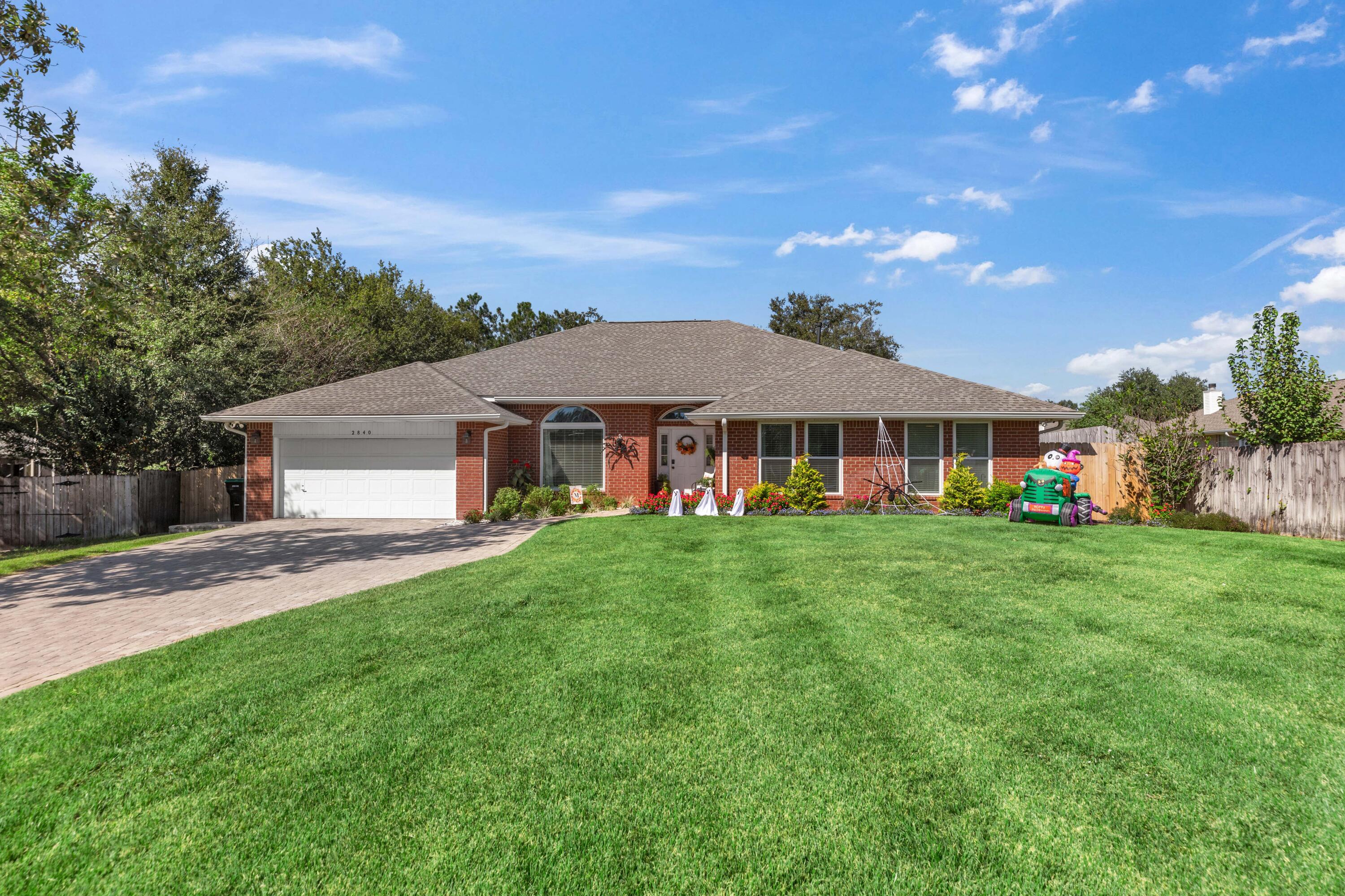 a front view of a house with yard and green space