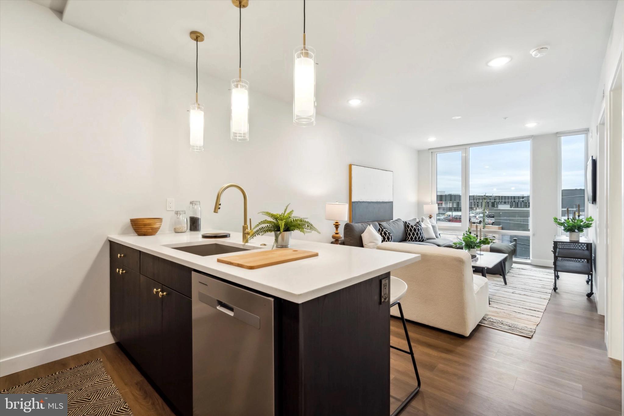 a kitchen with sink and view of living room