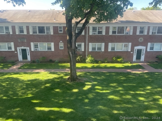 a front view of a house with a yard and trees