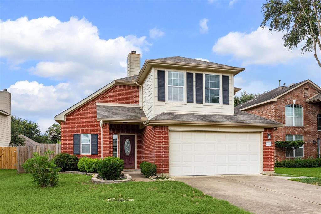 a front view of a house with a garden and yard