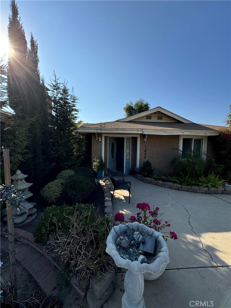 a front view of a house with lots of flower plants