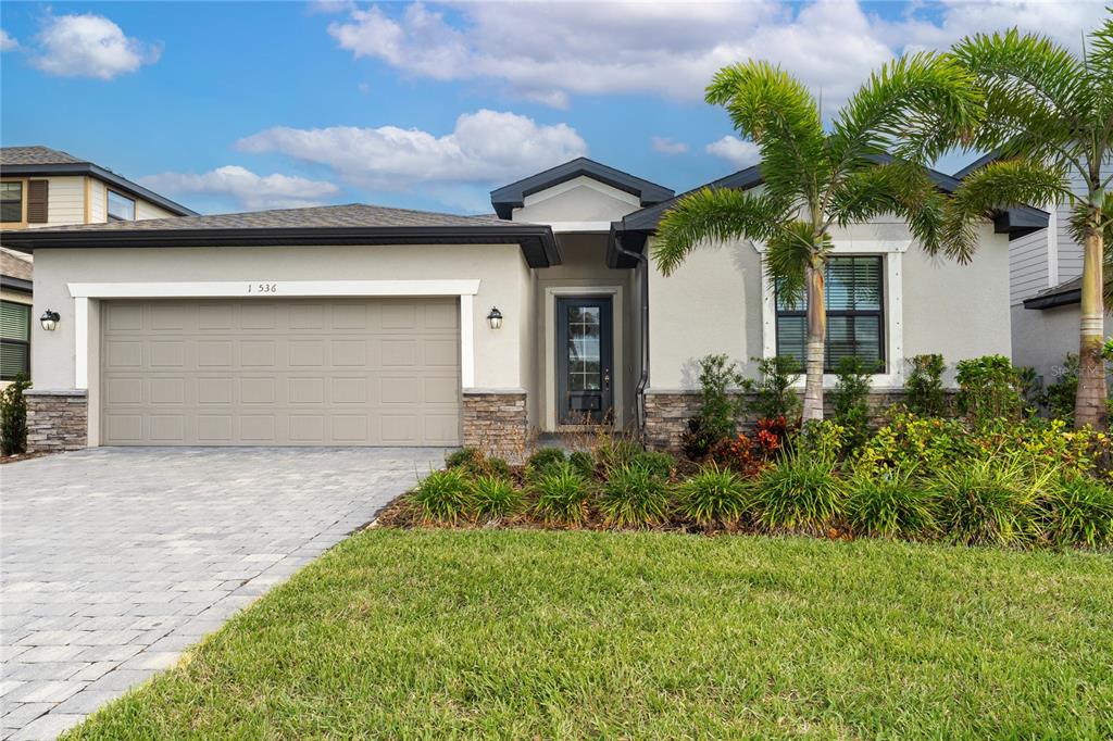 a front view of a house with a yard and a garage