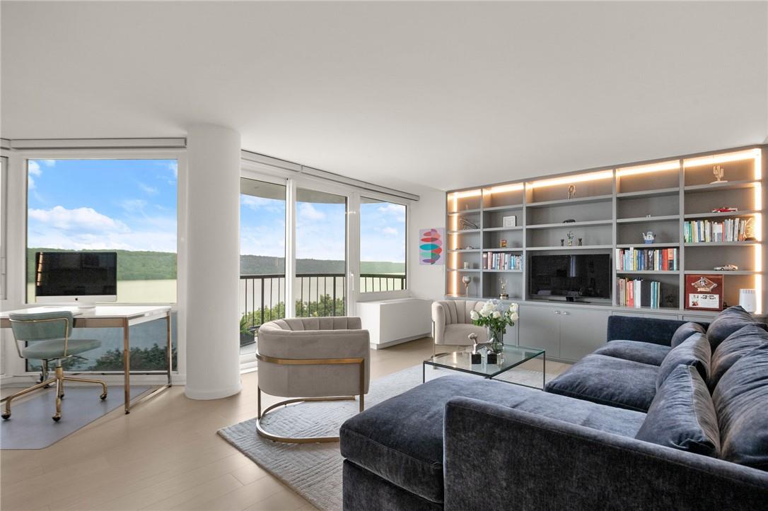 a living room with furniture a flat screen tv and a floor to ceiling window