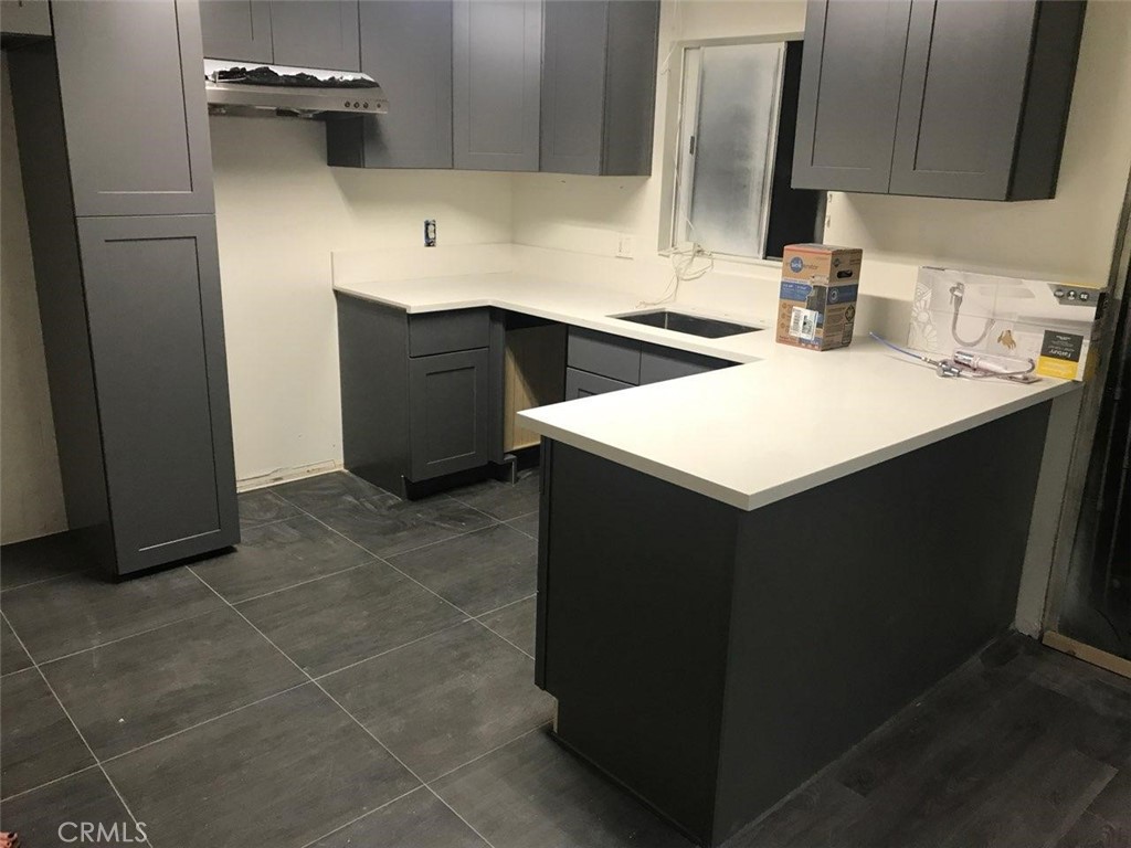 a kitchen with a sink a cabinets and black appliances