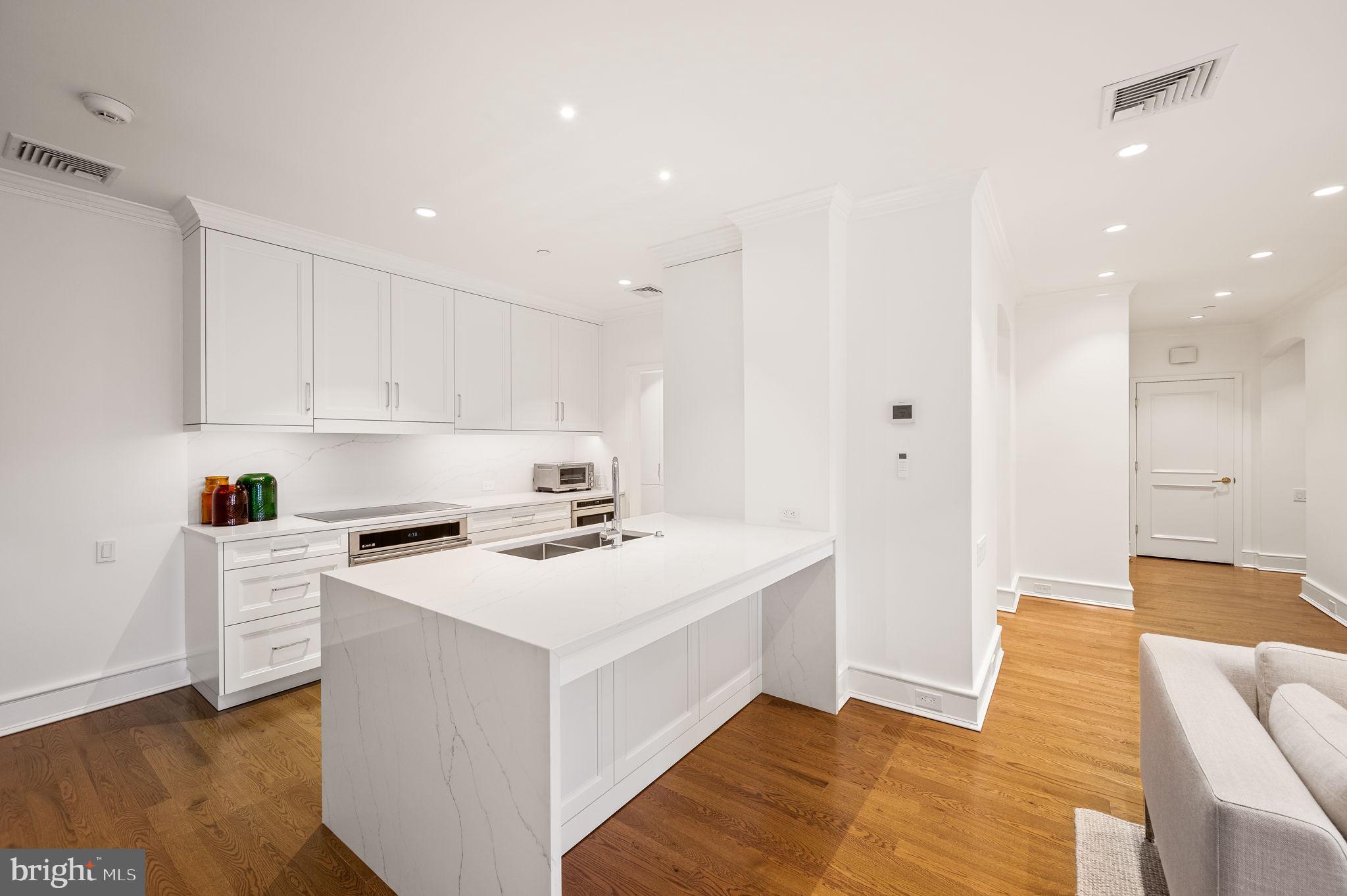 a view of kitchen with sink and refrigerator