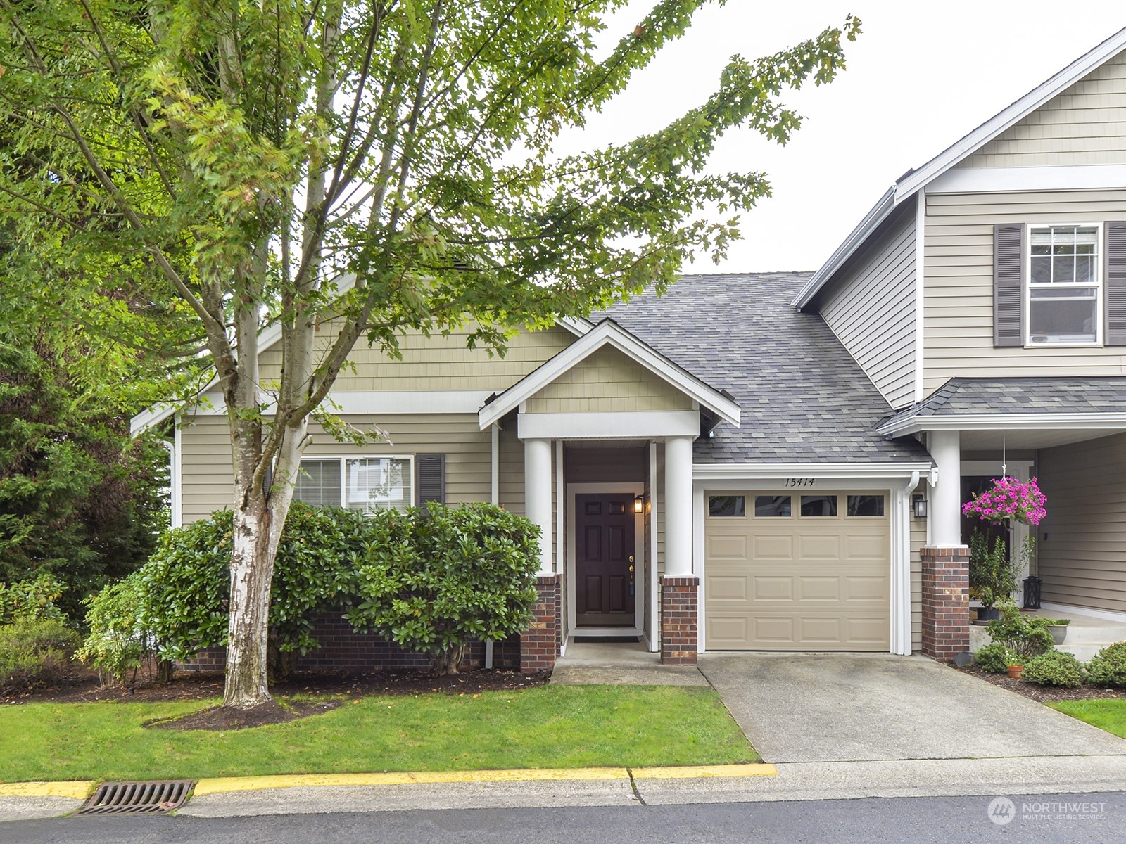 a front view of a house with a yard and potted plants