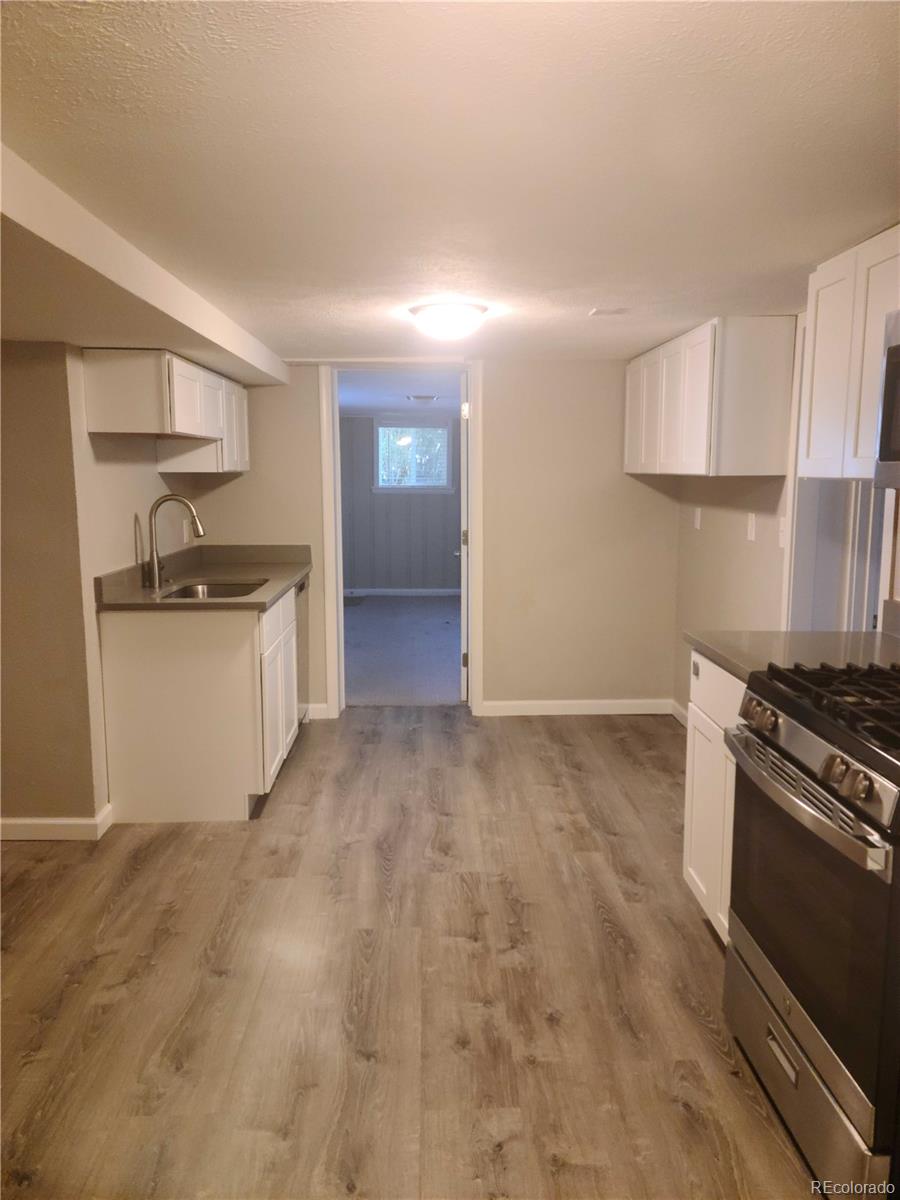 a kitchen with granite countertop a sink stove and refrigerator