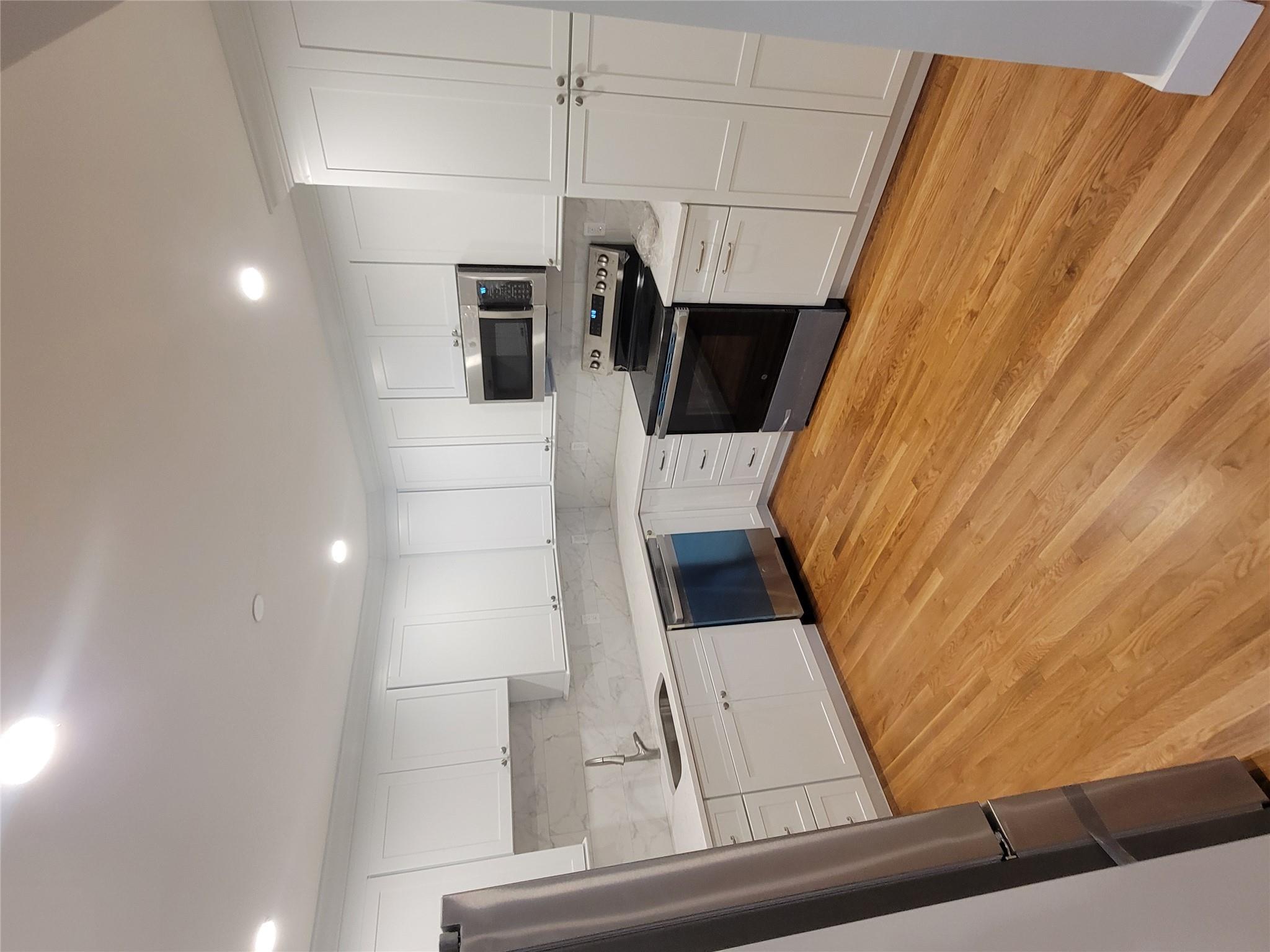 Kitchen with white cabinetry, sink, light hardwood / wood-style floors, and appliances with stainless steel finishes