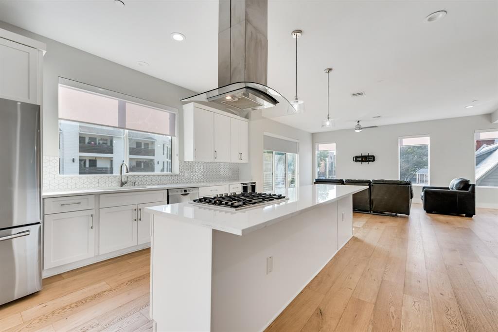 a large white kitchen with stainless steel appliances