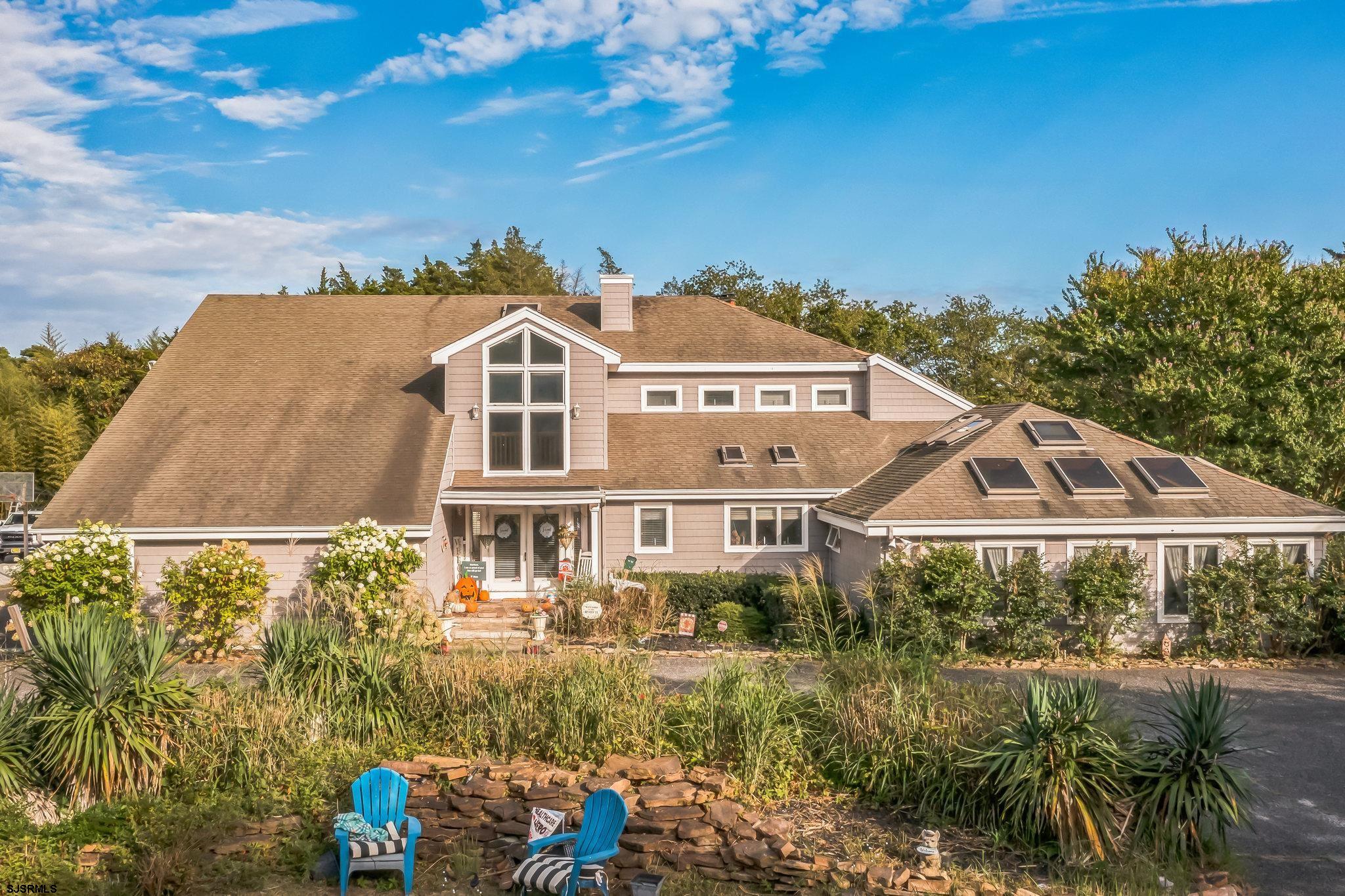 a front view of a house with a yard and lake view