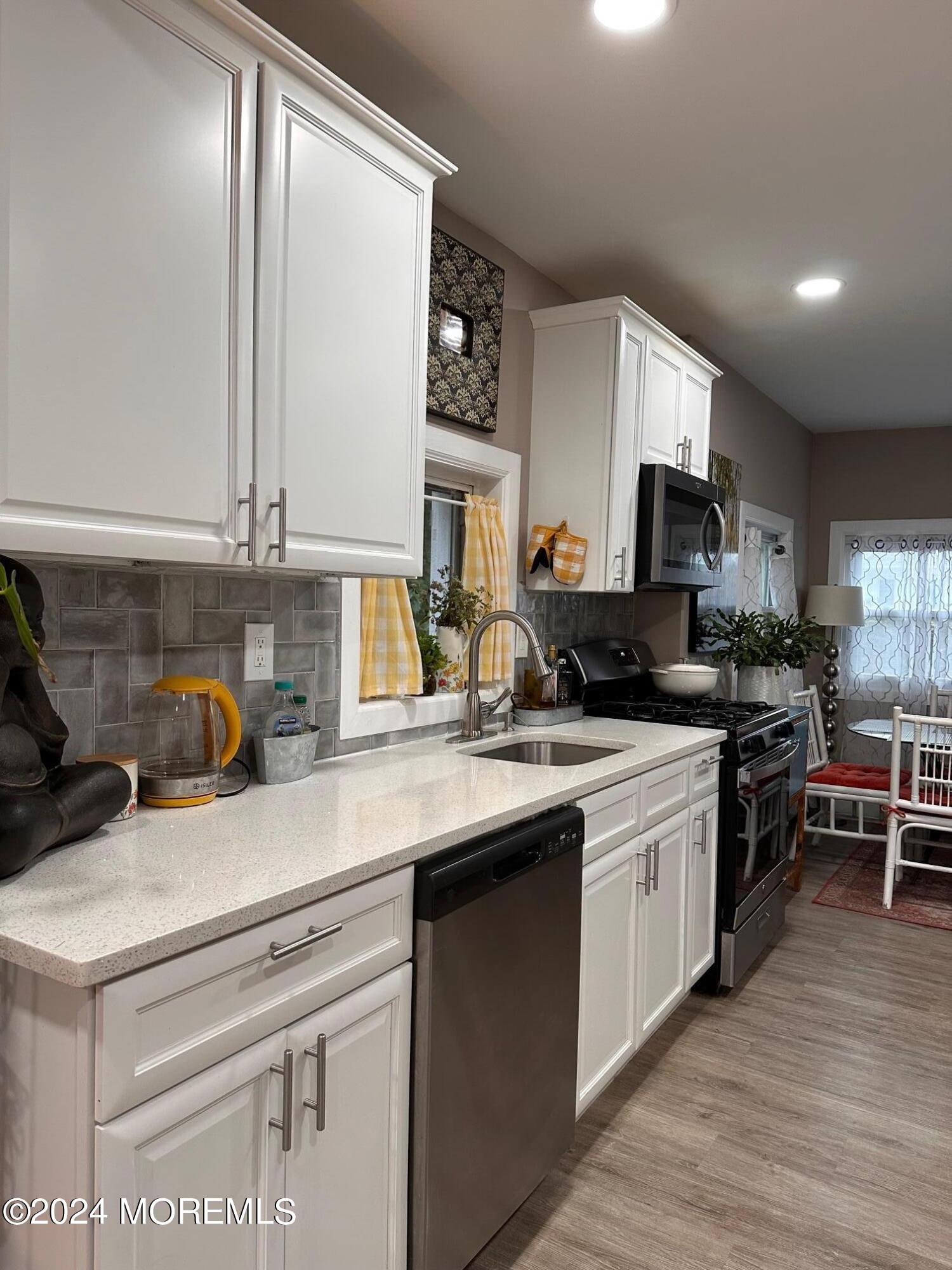 a kitchen with a sink stove and microwave