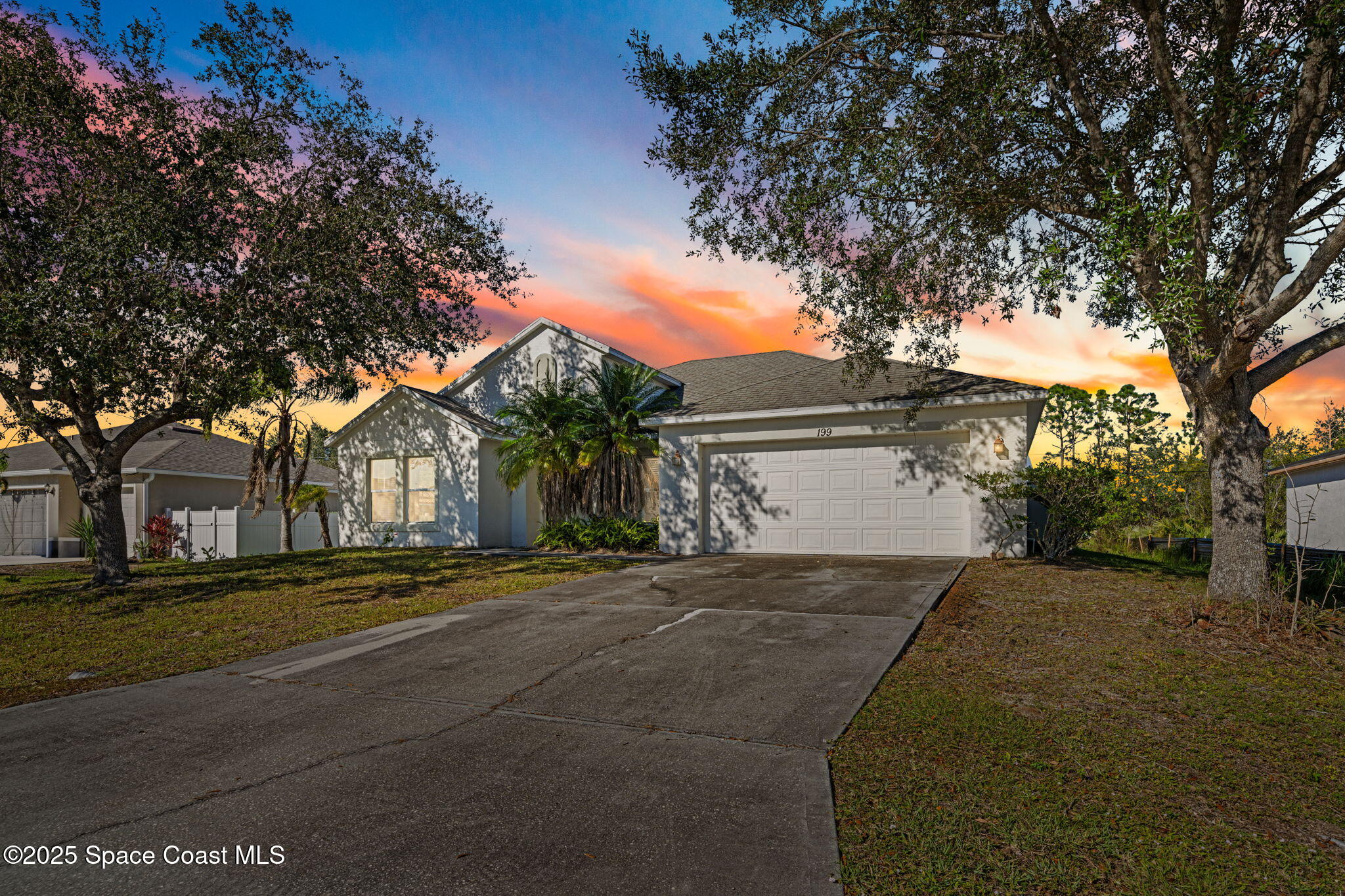 a front view of a house with a yard and trees