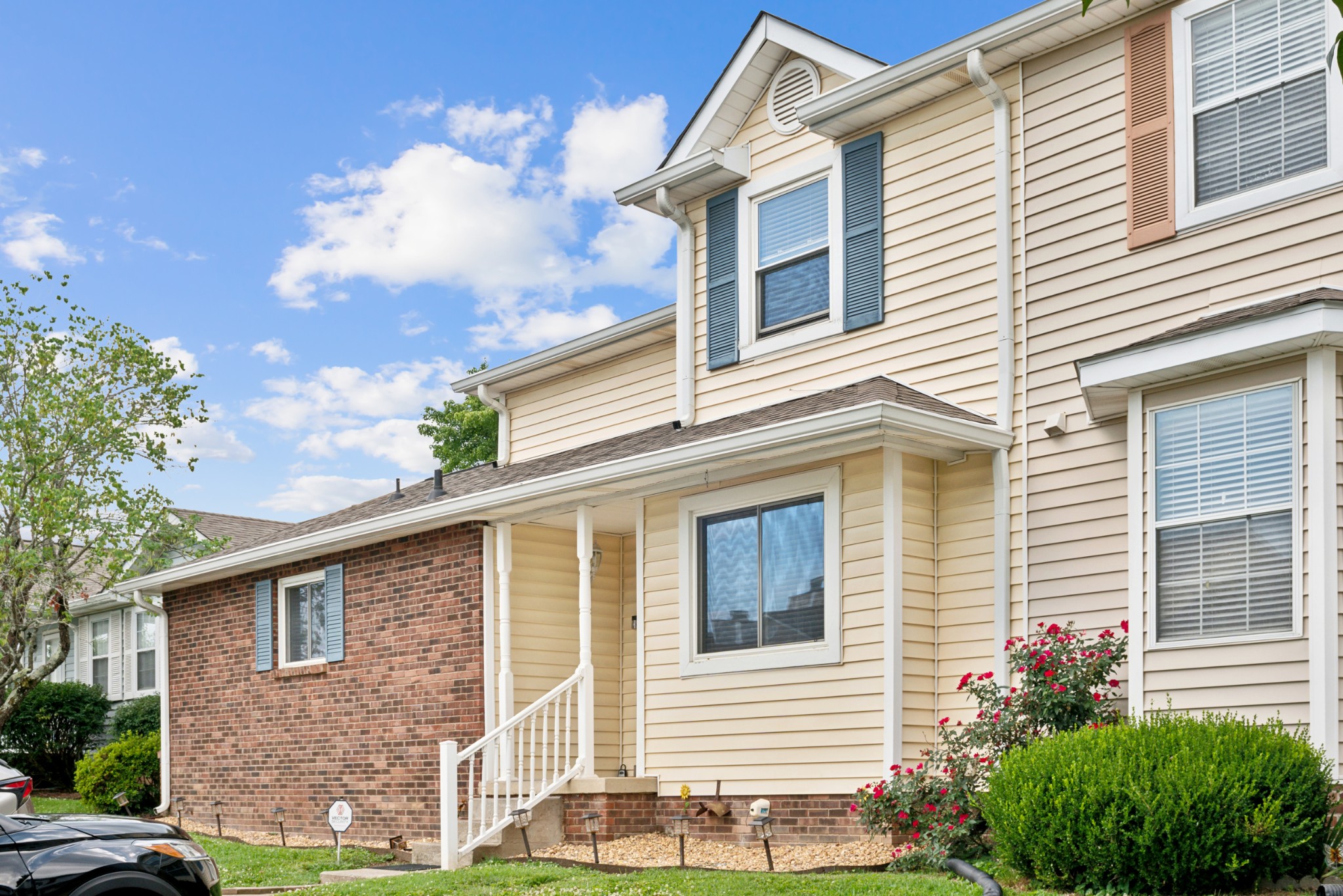 a view of a house with a yard and potted plants