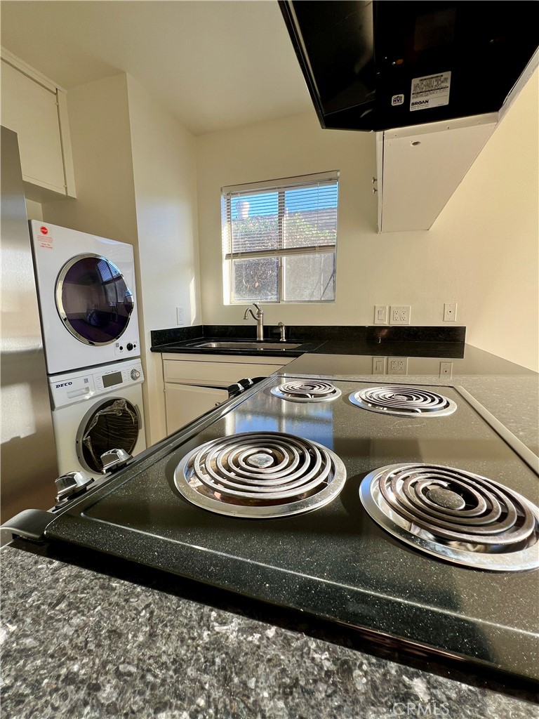 a kitchen with a stove and a wooden floor