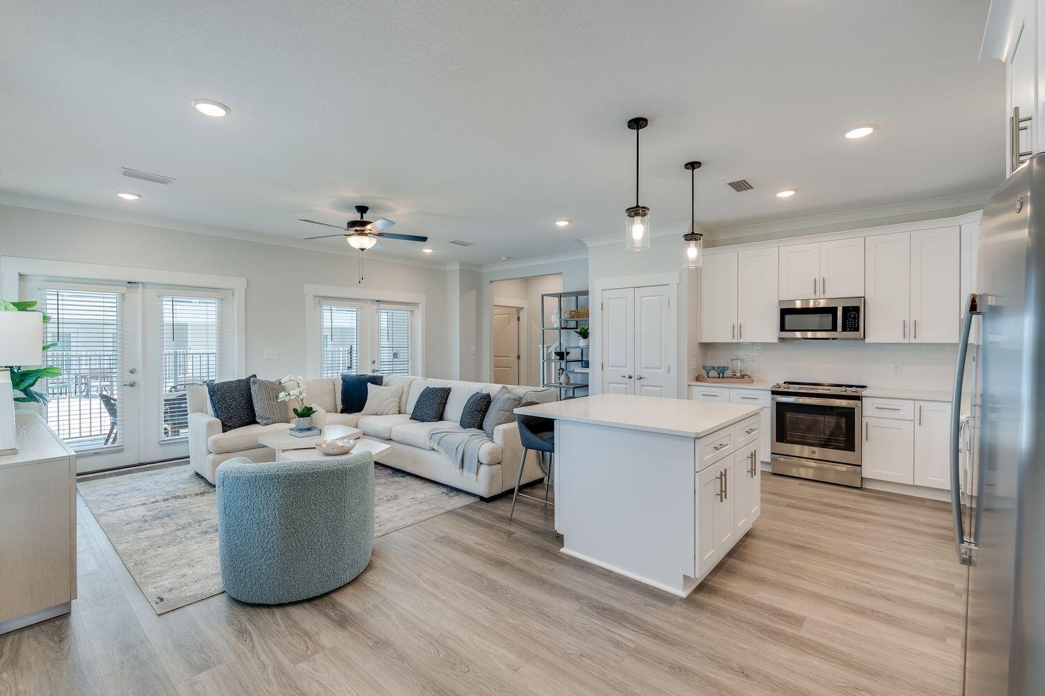 a large white kitchen with a stove a sink dishwasher and a refrigerator with wooden floor