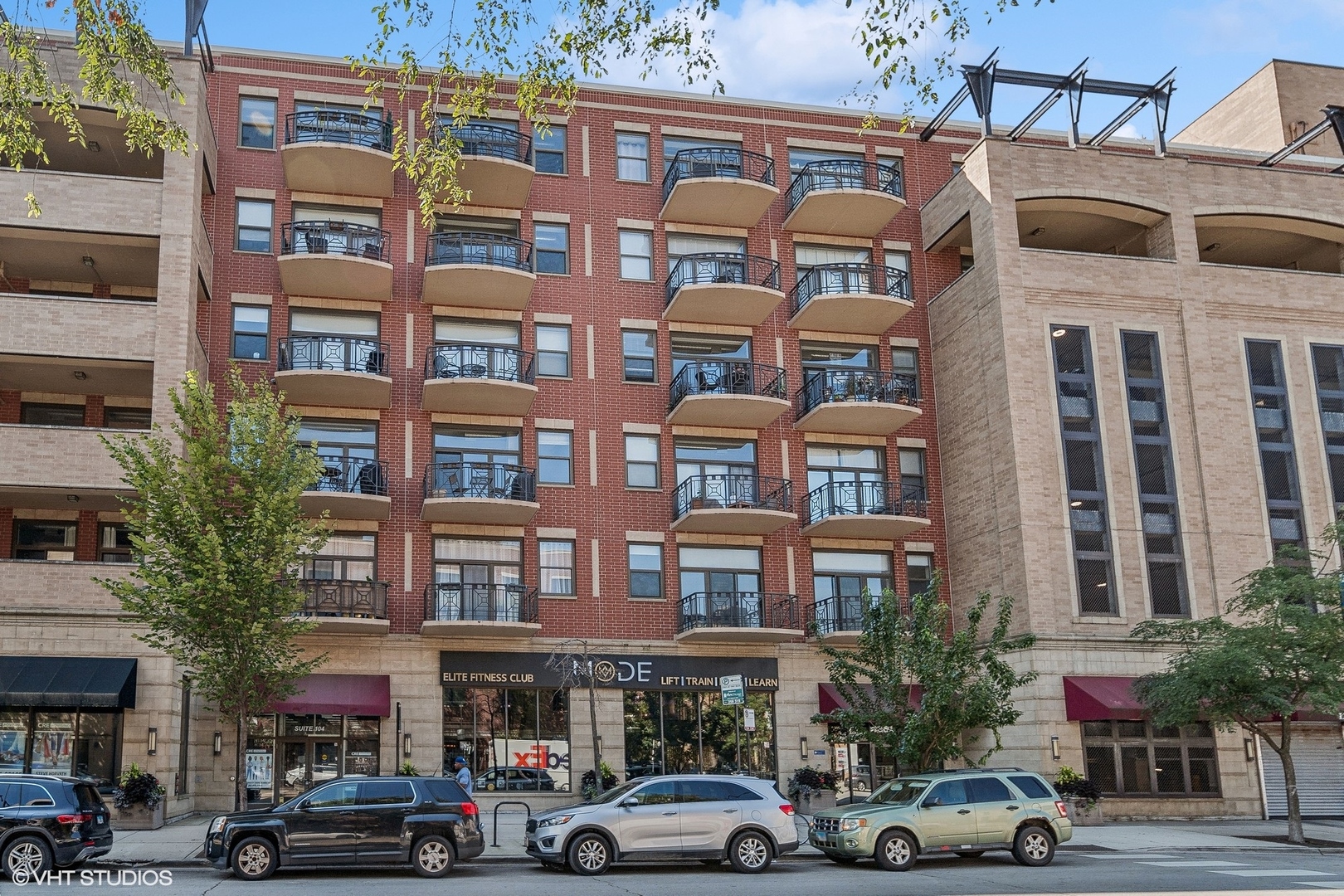 a front view of building with cars parked