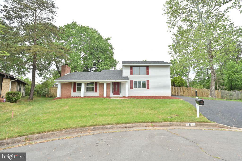 a front view of a house with a garden and trees