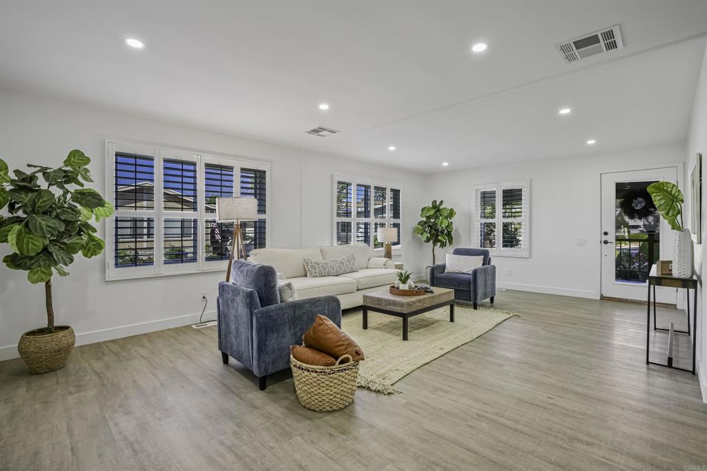 a living room with furniture and potted plants