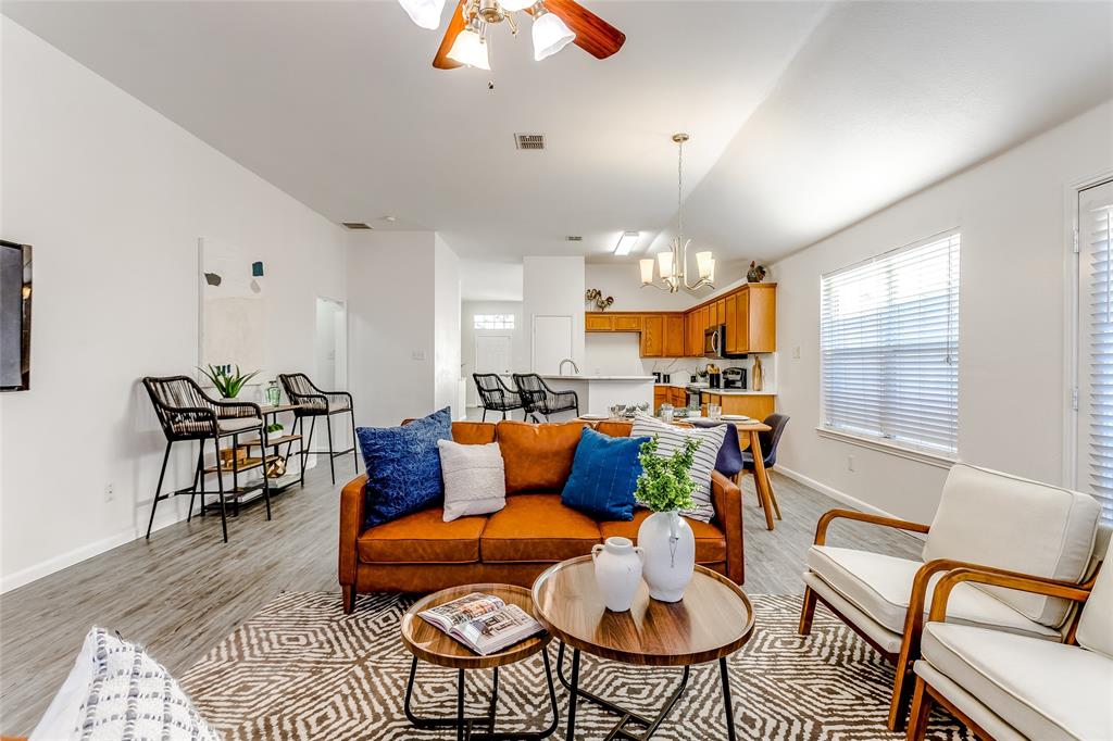 a living room with furniture kitchen view and a large window