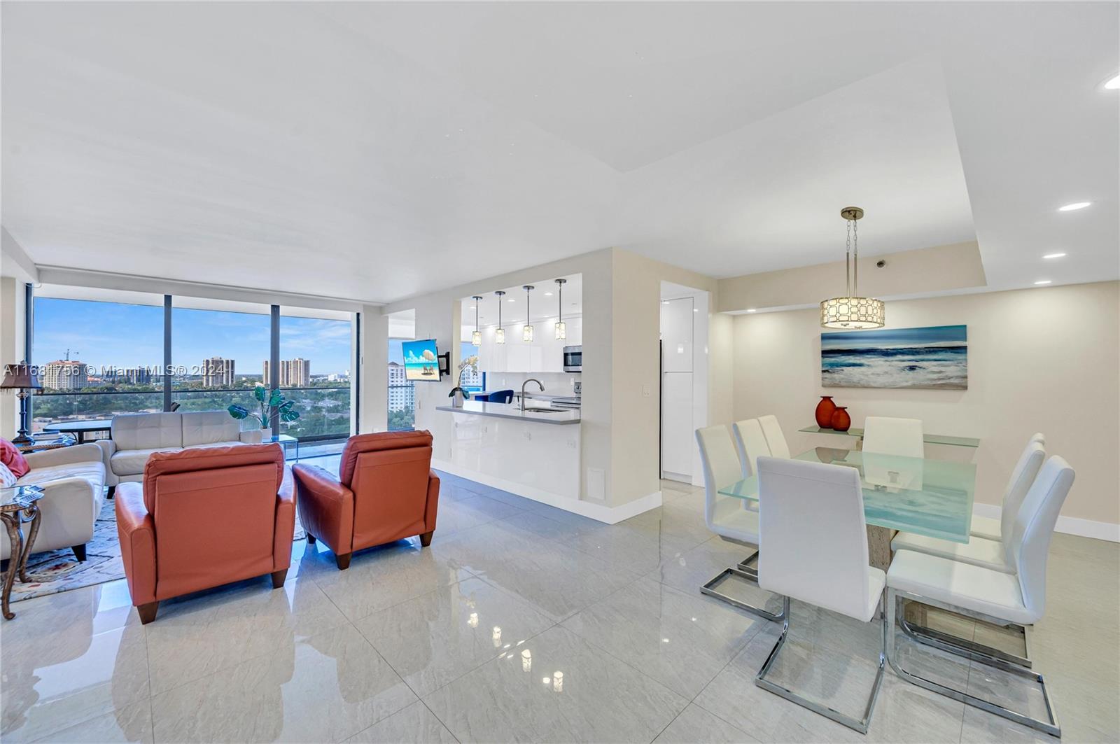 a room with furniture a rug kitchen view and a chandelier