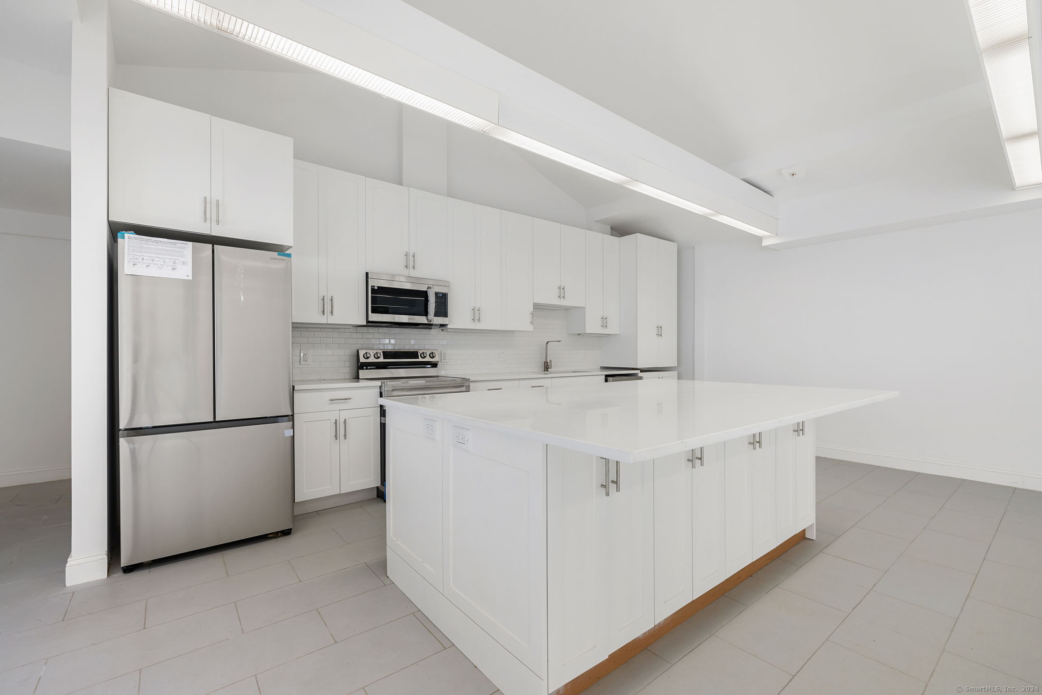 a kitchen with stainless steel appliances a refrigerator sink and microwave