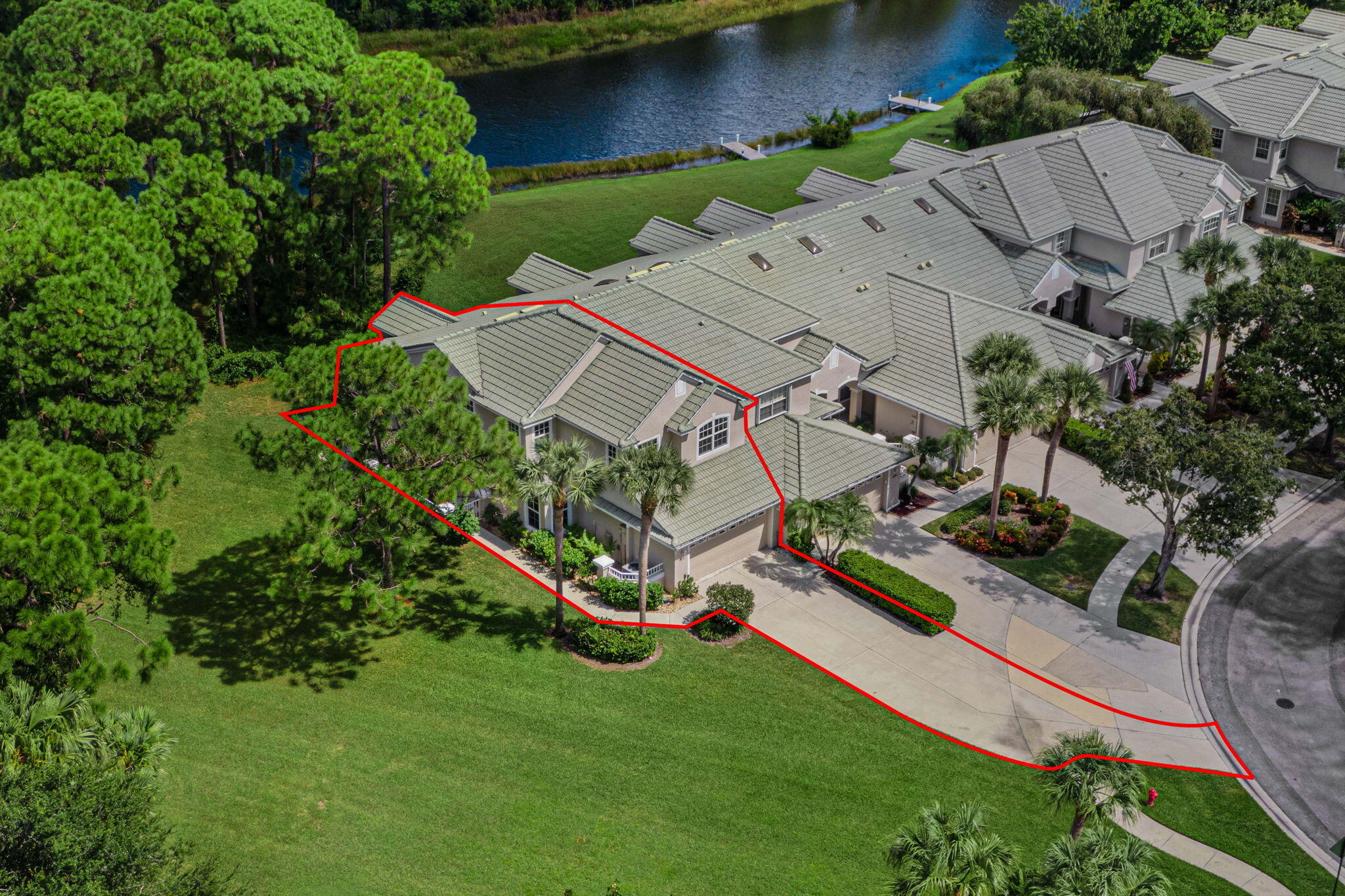 an aerial view of a house with a garden and lake view